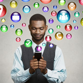 communication technology mobile phone high tech concept. business man using texting on smartphone social media application icons flying out of cellphone isolated grey wall background. 4g data plan